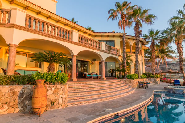 Hilltop villa with terracotta tile roof overlooking coastal town and blue ocean