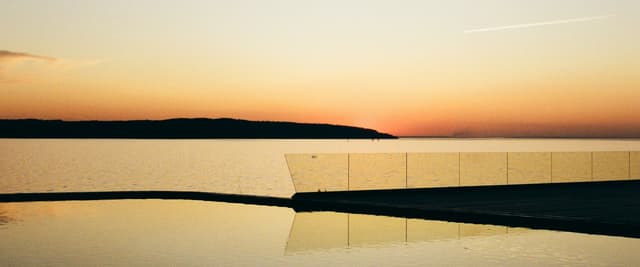 Infinity pool edge at sunset over a calm sea