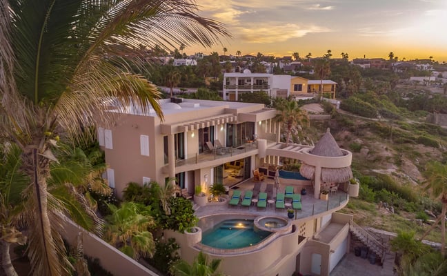 Beachfront villa with a private pool and sun loungers overlooking calm turquoise water